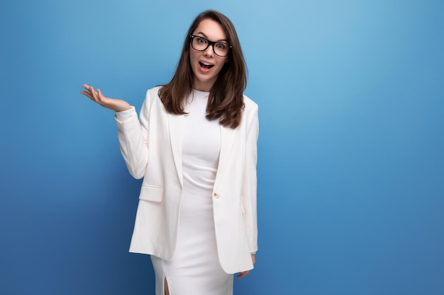 Elegante joven morena con vestido blanco muestra su confianza y sonrisa