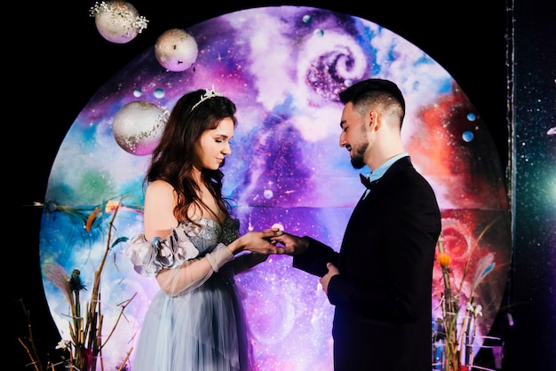 Foto elegante joven novia y el novio intercambiando anillos