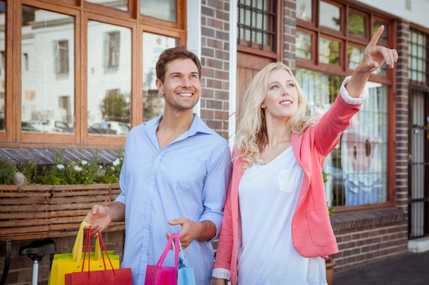 Elegante joven pareja caminando con bolsas de compras