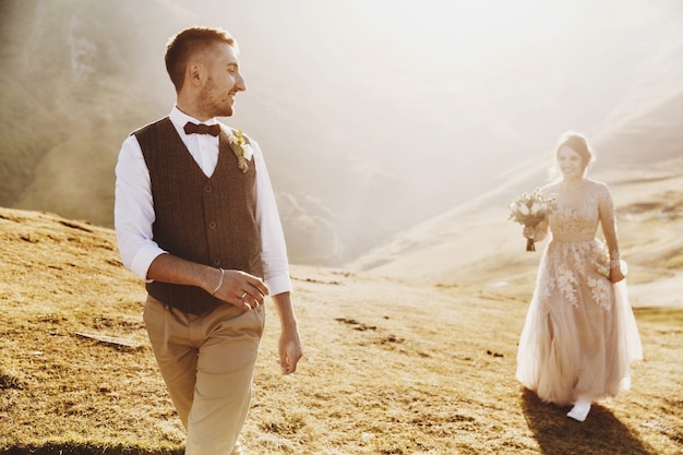 Elegante joven pareja se divierte posando en las hermosas montañas georgianas