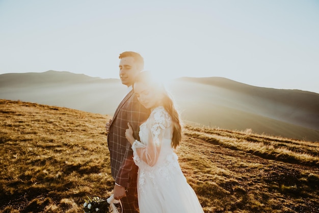 Elegante joven pareja de novios se divierte posando en hermosas montañas