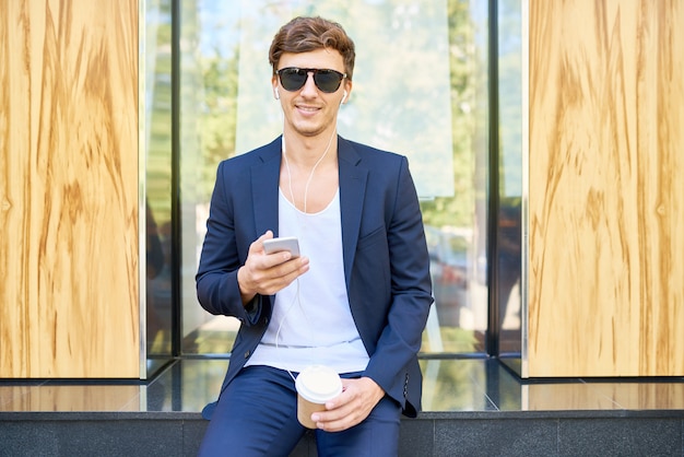 Elegante joven posando con smartphone