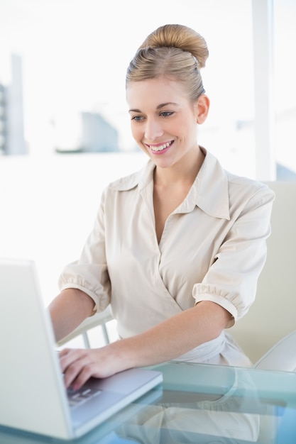 Elegante joven rubia empresaria usando una laptop