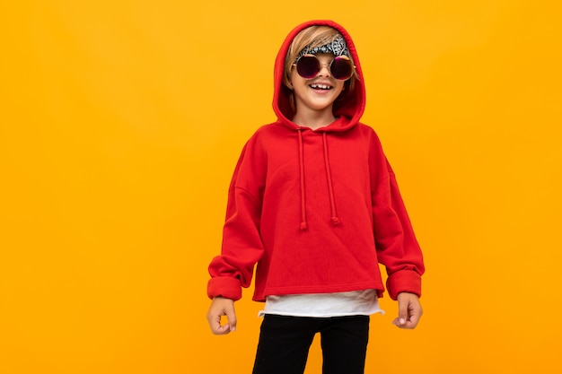 Elegante joven con sudadera roja y camiseta blanca pone las manos sobre su pecho