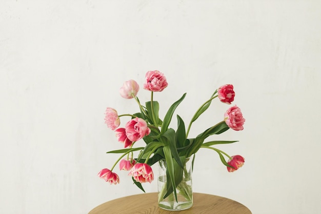 Elegante lindo buquê de tulipas cor de rosa em vaso na mesa de madeira na sala rústica Arranjo floral em casa de fazenda Flores da primavera espaço para cópia Feliz dia das mães e mulheres