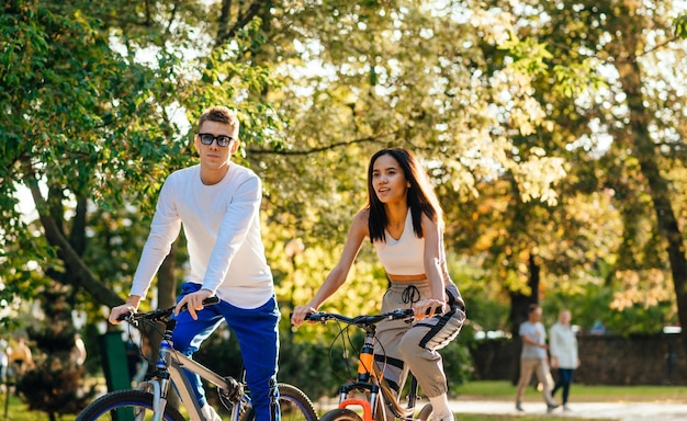 Elegante lindo casal anda de bicicleta no outono park Y