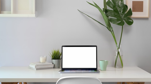 Elegante loft en el área de trabajo con computadora portátil con pantalla en blanco.