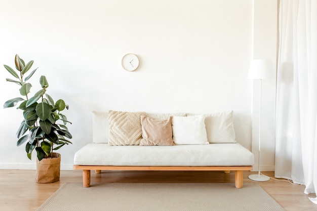 Elegante y luminosa sala de estar con sofá de madera con almohadas de estilo escandinavo