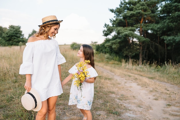 Elegante madre e hija guapa divirtiéndose en la naturaleza