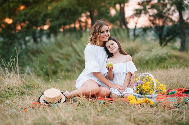 Elegante madre e hija guapa divirtiéndose en la naturaleza