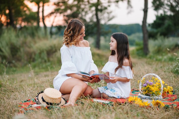 Elegante madre e hija guapa divirtiéndose en la naturaleza