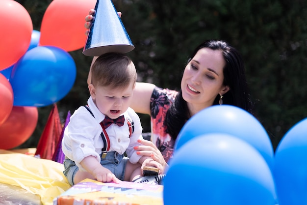 Elegante madre hijo pequeño fiesta de cumpleaños celebración del primer cumpleaños Globos sombreros de fiesta