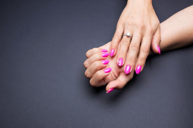 Elegante manicura rosa sobre negro