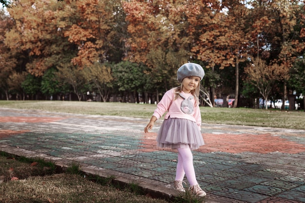 Elegante menina andando no parque outonal