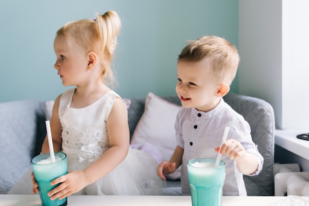 Elegante menino e menina em um café infantil bebendo um milk-shake