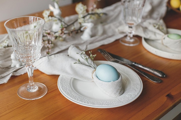 Elegante mesa de brunch de Páscoa, configuração de ovo de Páscoa em guardanapo de coelho no prato