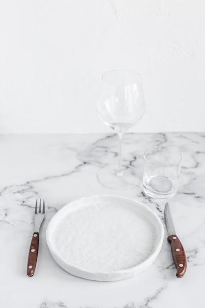 Elegante mesa elegante con placa de cerámica sobre fondo de mármol blanco