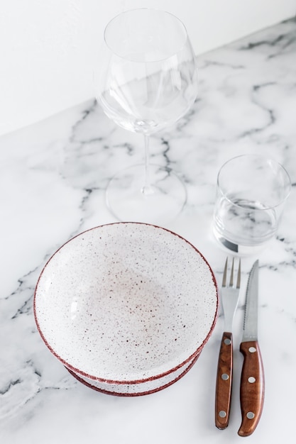 Foto elegante mesa elegante con placas de cerámica sobre fondo de mármol blanco.