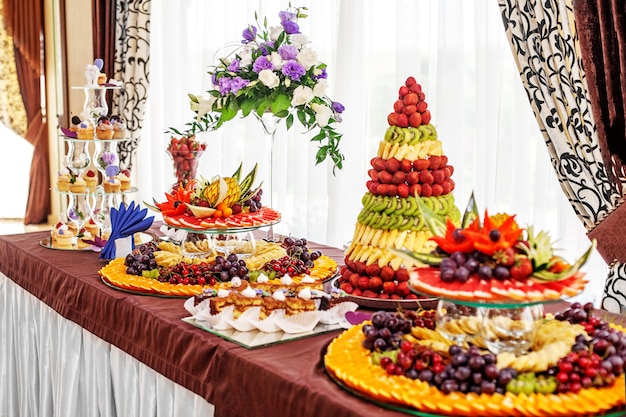 Elegante mesa con frutas y pasteles. El concepto de una fiesta, la comida.