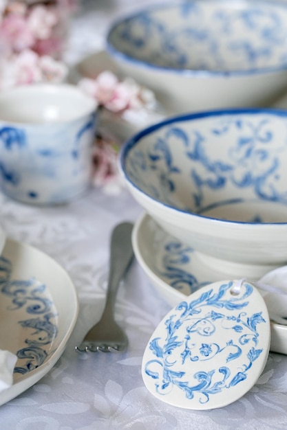 Foto elegante mesa de pascua con adornos marinos vacíos vajilla de porcelana pintada platos y tazones decoraciones de huevos de pascua en mantel blanco cena navideña de pascua