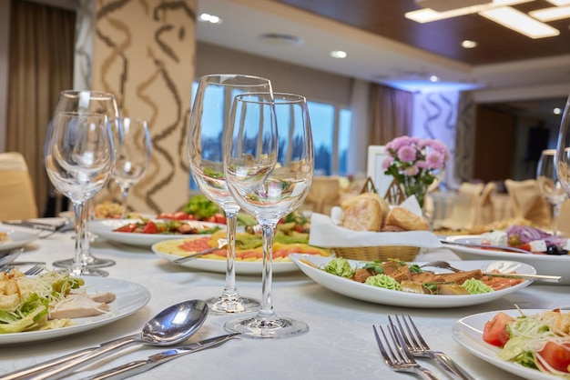 Elegante mesa con un ramo Juego de comedor de lujo con cubiertos, servilletas, vajilla y cubierto con un mantel en el restaurante