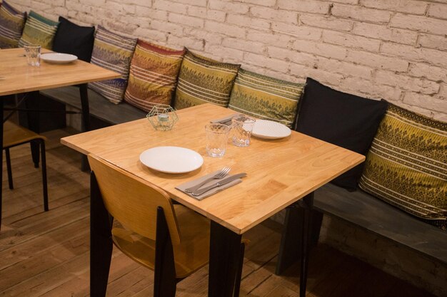 Foto elegante mesa de restaurante con cubiertos, vajilla y vasos.