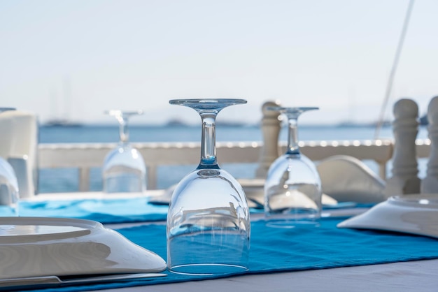 Elegante mesa con tenedor, cuchillo, copa de vino, plato blanco y servilleta azul en el restaurante. Bonito juego de mesa con cubiertos y servilletas para la cena.