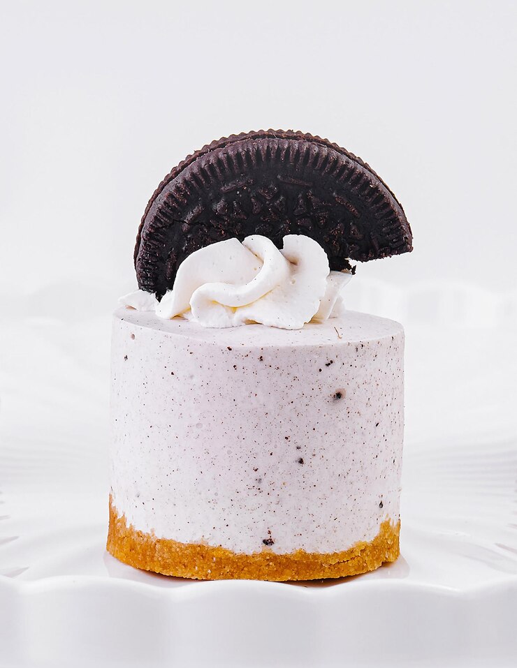 Elegante mini pastel de queso con guarnición de galletas en soporte blanco