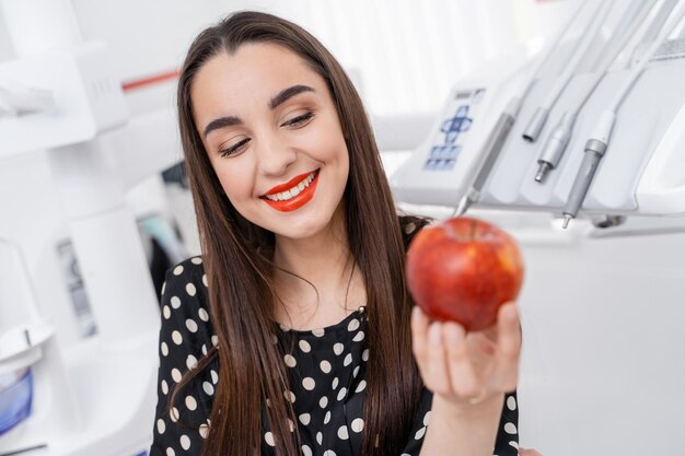 Elegante modelo feminino alegre com maçã. retrato de mulher muito jovem smilling.