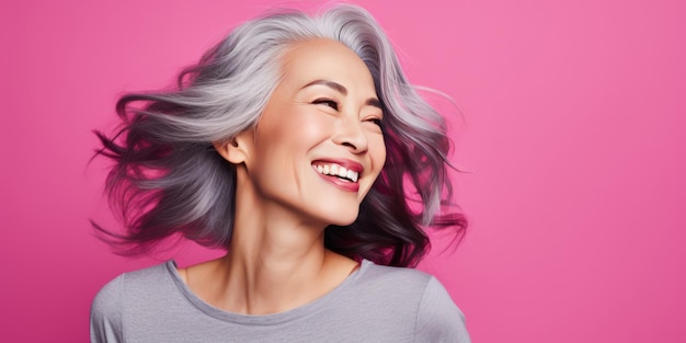 Una elegante mujer asiática de unos 50 años Lujosa mujer de mediana edad con un peinado corto sobre fondo rosa