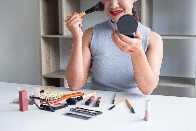 Foto elegante mujer blogger de belleza que muestra pruebas de productos cosméticos de belleza.