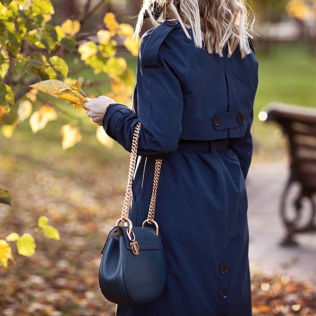 Elegante mujer camina en el parque otoño.