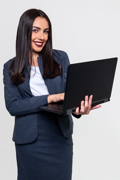 Elegante mujer ejecutiva sonriendo sosteniendo un cuaderno y aislado sobre fondo blanco.