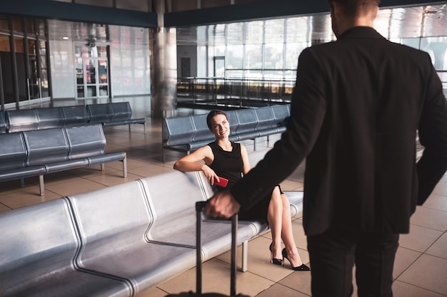 Elegante mujer y hombre reunidos en el aeropuerto