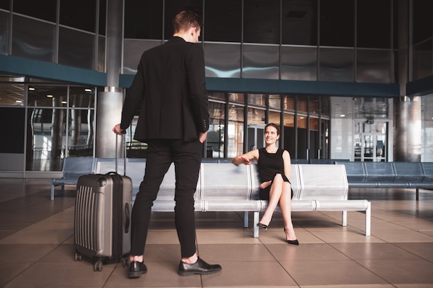 Elegante mujer y hombre reunidos en el aeropuerto