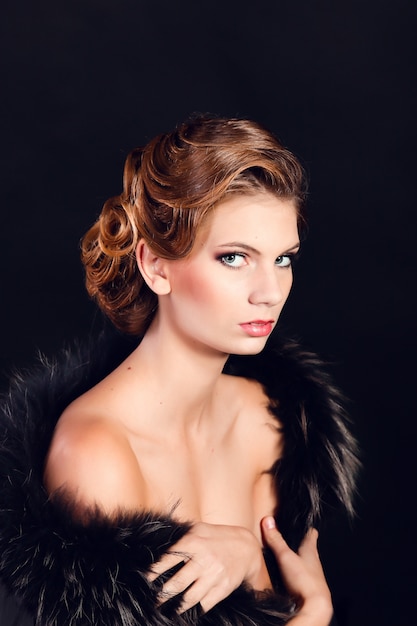 Elegante mujer joven en ropa interior negro posando en el estudio.