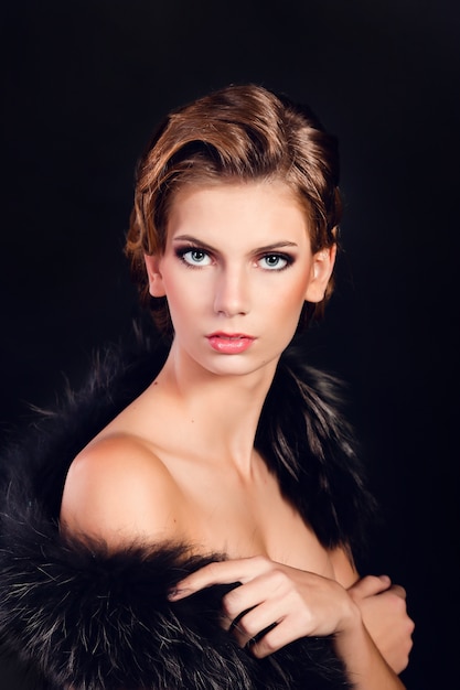 Elegante mujer joven en ropa interior negro posando en el estudio.