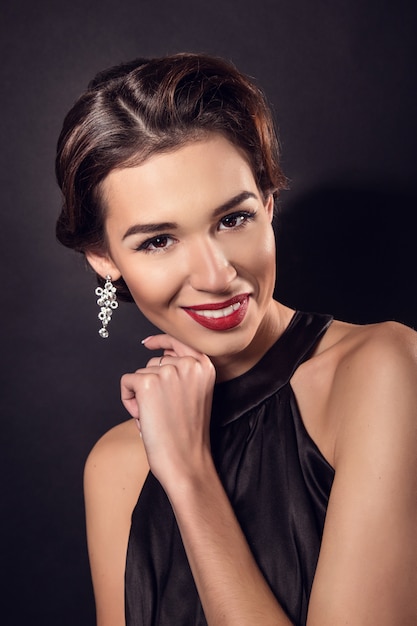 Elegante mujer joven en ropa interior negro posando en el estudio.