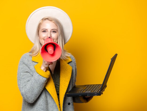 Elegante mujer con megáfono y laptop