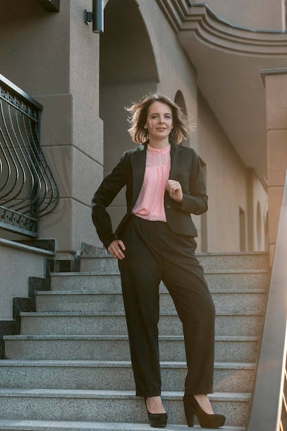 Elegante mujer de moda en ropa formal de negocios fuera de mujer con traje  negro