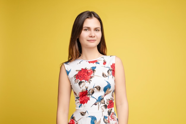 Elegante mujer morena en vestido de flores