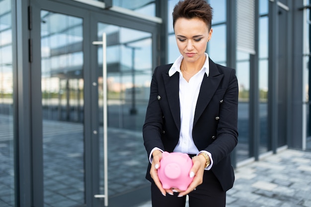 Elegante mujer de negocios en el fondo de un edificio de oficinas de moda