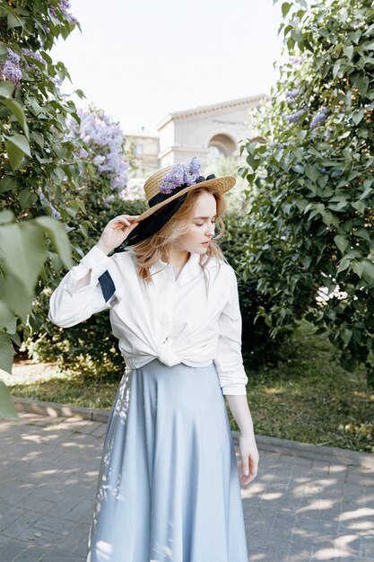 Elegante mujer rubia en un jardín floreciente