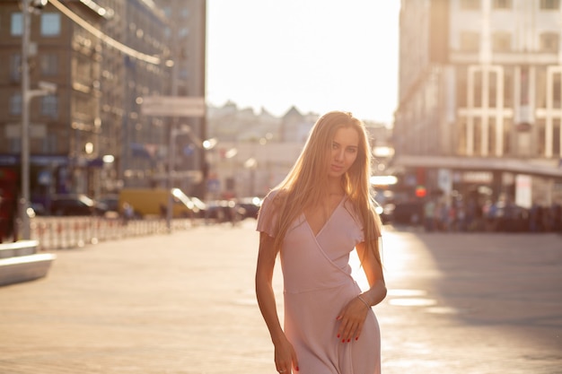 Foto elegante mujer rubia posando en la calle en rayo de sol. concepto de moda de estilo de vida. espacio para texto