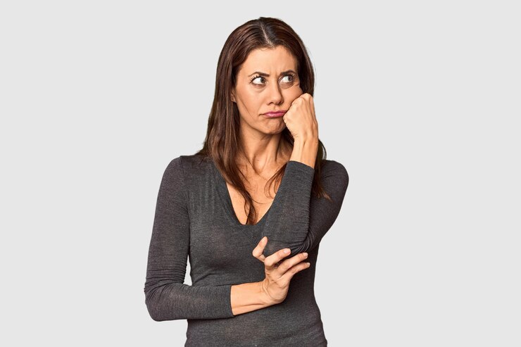 Foto elegante mulher caucasiana de meia-idade em um ambiente de estúdio que se sente triste e pensativa olhando para o espaço de cópia