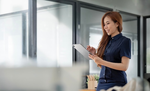 Elegante, mulher negócios fica, em, escritório, com, tablete digital