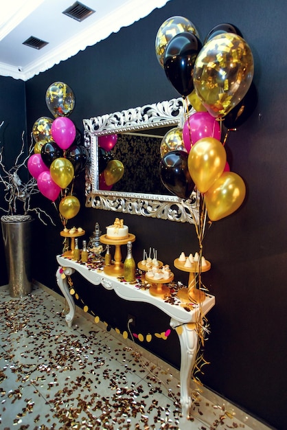 Elegante murciélago de caramelo decorado de lujo con globos en el concepto de celebración navideña de la fiesta de cumpleaños dorada