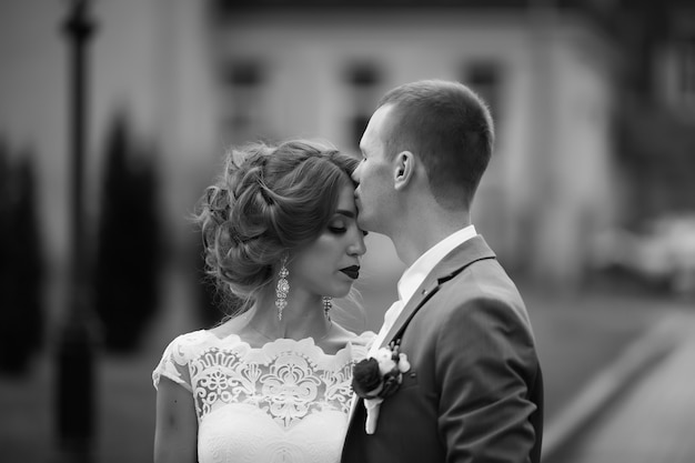 Elegante noiva e noivo posando juntos ao ar livre no dia do casamento