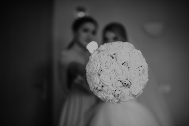 Elegante novia feliz vistiendo vestido sonriendo a las damas de honor en la ventana preparación rústica de la mañana de la boda nupcial preparándose momento emocional espacio para texto foto en blanco y negro