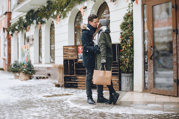 elegante pareja amorosa caminando en la ciudad de la primavera con bolsas de compras